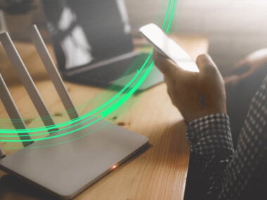 10 tips to improve your Wi-Fi signal article hero - Person checking Wi-Fi signal strength on a phone at home